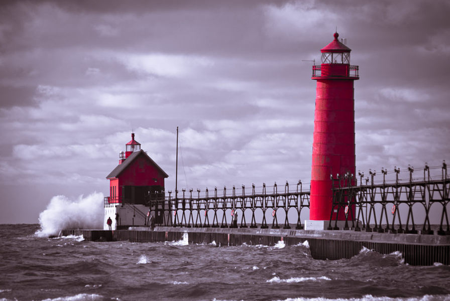 The red Grand Haven South Pier lighthouses over the rough waters of Lake Michigan