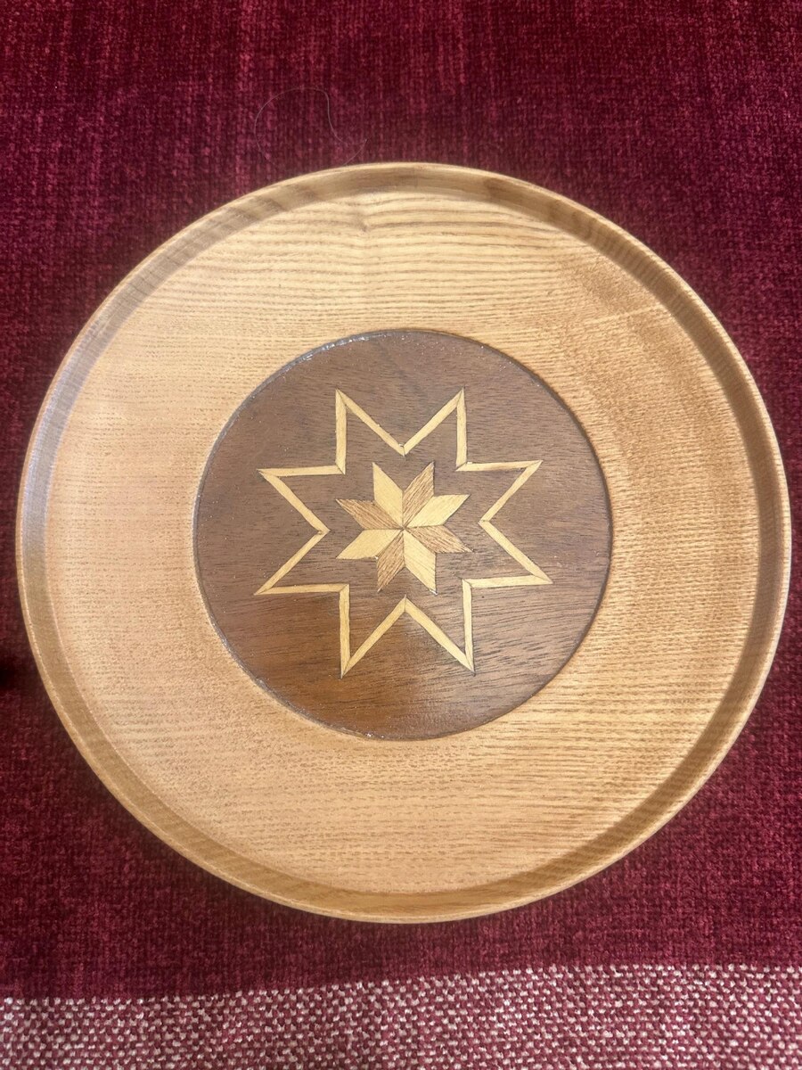 Carved wooden plate with a traditional Latvian star (Auseklis) motif
